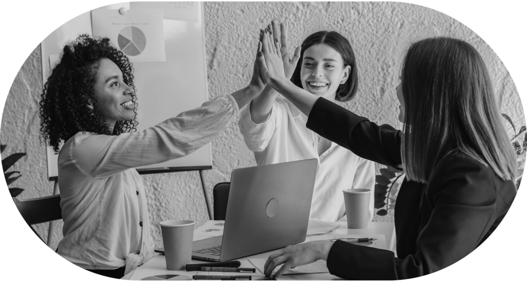 three women having a group high-five over laptop